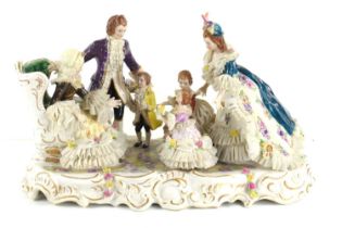 A continental porcelain figure group of a family in 18th century dress handpainted with bocage and