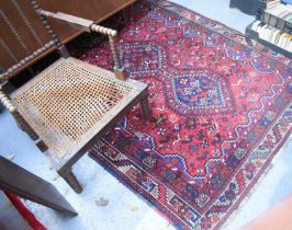 A Middle Eastern rug with deep red ground depicting various birds around a triple diamond centre and