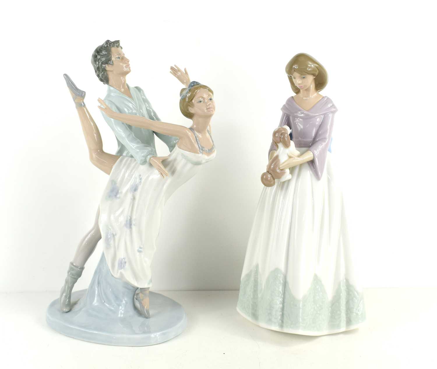 Two Lladro Nao figurines, Dancing on a Cloud, 32cm high, together with a lady holding her spoiled