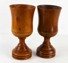 A pair of treen goblets, turned to form stepped bases, 18cm high.