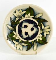 A Moorcroft plate, in the Blueberry and white lily pattern, 26cm diameter, dated verso 2000.