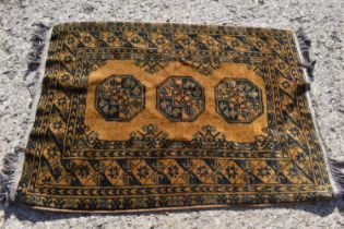 A small Middle Eastern yellow ground rug with three octagonal motifs to the centre, 100 by 143cm.