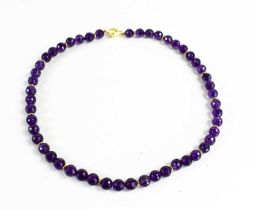 An 18ct gold and amethyst necklace the fifty circular deep violet coloured beads honeycomb cut