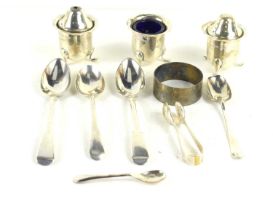 A group of silver to include cruet set, sugar nips, spoons, and a napkin ring.
