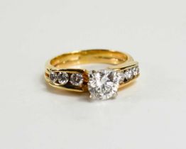 An 18ct yellow gold and diamond ring by Gordons, the central brilliant cut diamond approximately