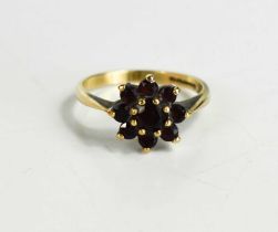 A 9ct gold and garnet flowerhead ring, set with central round cut garnet, surrounded by eight