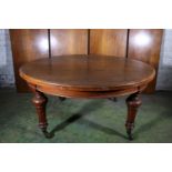 Victorian oak telescopic dining table raised on turned and fluted supports capped by castors, the