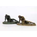 Two 20th century bronze castings of a fallen Roman soldier, modelled sat upon his Gladius type