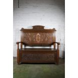 Antique carved oak settle hall bench decorated with carved thistle and floral designs, 122cm long.