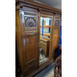 A John Taylor & Son of Edinburgh three door wardrobe, with moulded and dentil cornice over shell and
