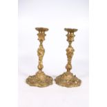 Pair of 19th century gilt metal candlesticks in the Rococo style with relief scrolling foliage, 31cm