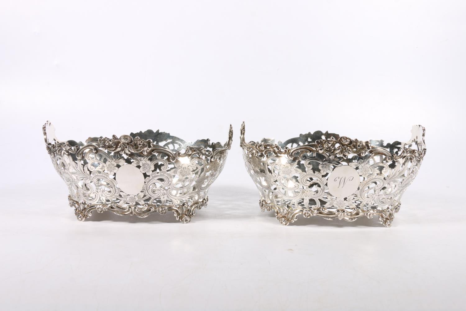 Two Victorian silver baskets with ornate relief and pierced work floral bodies, different makers