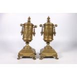 Pair of French brass clock garniture supporting vases of urn shape with ornate handles raised on