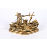 French gilt metal deskstand in the form of a boat with young man hauling in catch, the inkwell