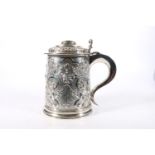 Edwardian silver lidded tankard, the body decorated with relief designs including mask of Bacchus