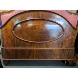 Victorian mahogany framed double bed, the headboard with serpentine top rail and pink fabric