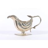 Edwardian silver cream jug with flower and scroll border and serpent handle raised on diamond shaped