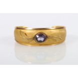 18kt yellow gold bangle set with faceted amethyst stone, the texture body with two relief leaves,