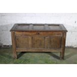 Antique oak coffer with hinge top opening to reveal interior with candle well, raised on straight