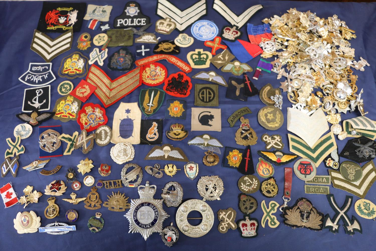 Large collection of military cap badges etc. to include an Argyll and Sutherland Highlanders plaid