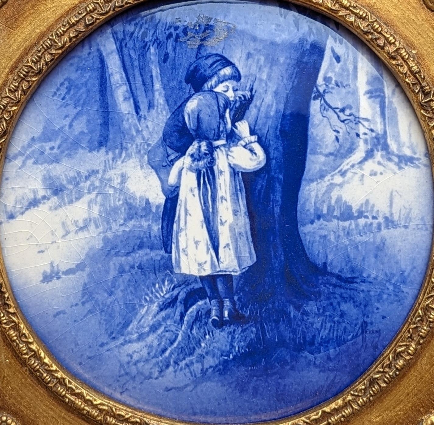 19th century Delft porcelain blue and white convex plaque depicting two children hiding by a tree,