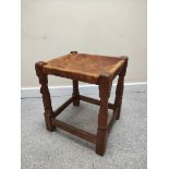 Robert "Mouseman" Thompson, oak stool with rectangular hide top on faceted turned support with