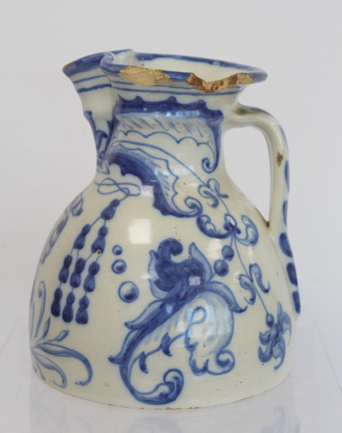 Spanish Talavera de la Reina tin glazed blue and white jug of domed form with trefoil rim, decorated