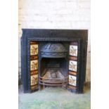 A Victorian cast iron fire surround, with foliate decorated dome hood over fire basket flanked by