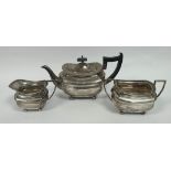 Silver three-piece tea set of rounded rectangular shape, Walker & Hall Sheffield 1931. 1304g /