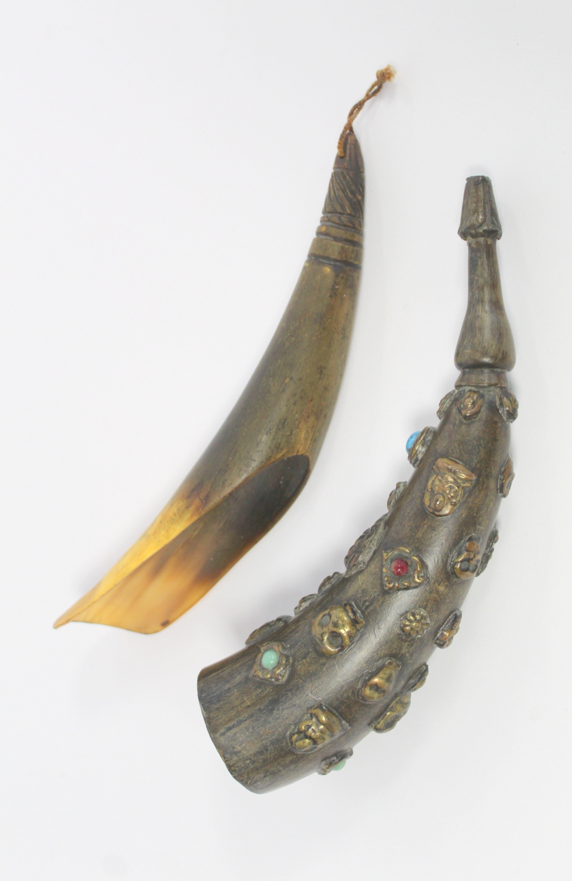 Tibetan horn with carved and shaped end and applied repousse metal masks with inset turquoise and