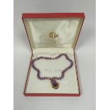 Victorian pendant in gold scrolling mount upon amethyst and citrine faceted bead necklet.