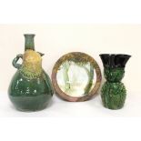 Studio pottery bottle vase with owl mask head, twin scroll handles and green and brown glazes,
