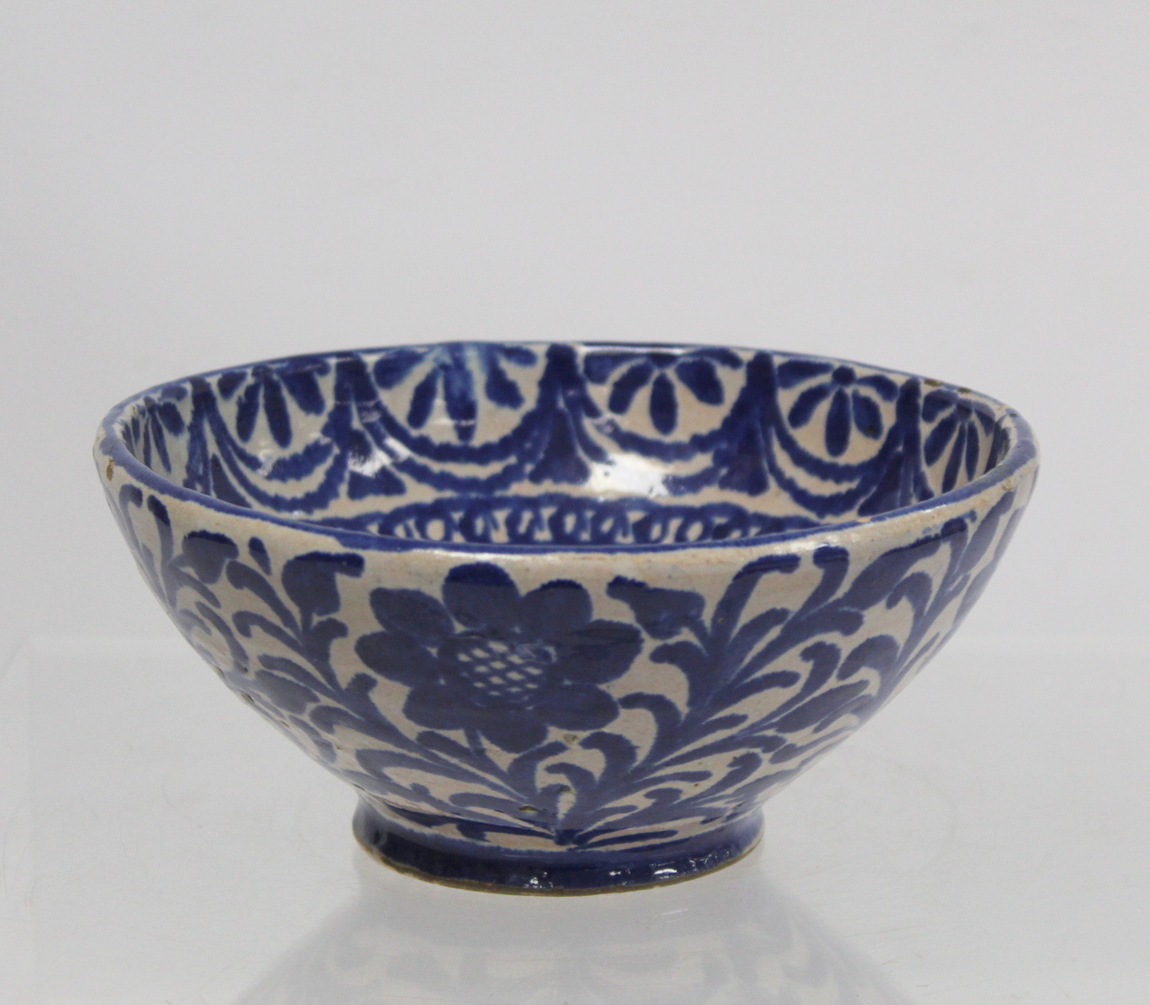 Middle Eastern small earthenware blue and white circular bowl decorated with stylised flowers and