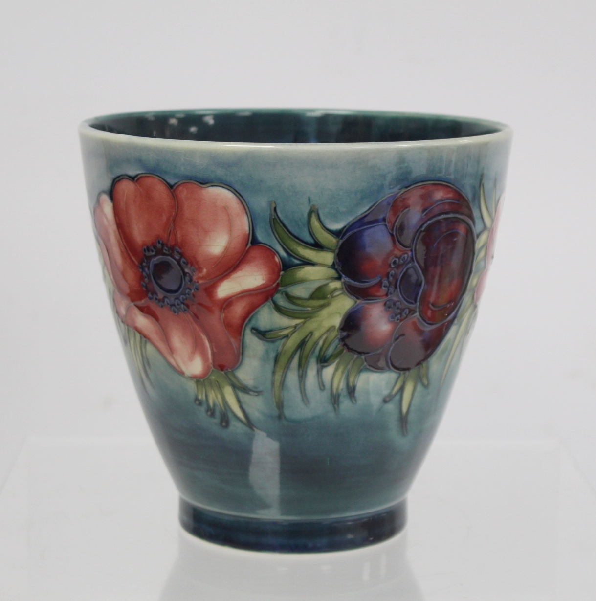 Moorcroft Pottery "Anemone" pattern vase of flared form with blue green ground, painted initials