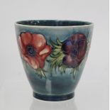 Moorcroft Pottery "Anemone" pattern vase of flared form with blue green ground, painted initials