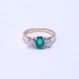 Diamond and emerald three-stone ring, the oval emerald approximately .72mm x 5mm, between two