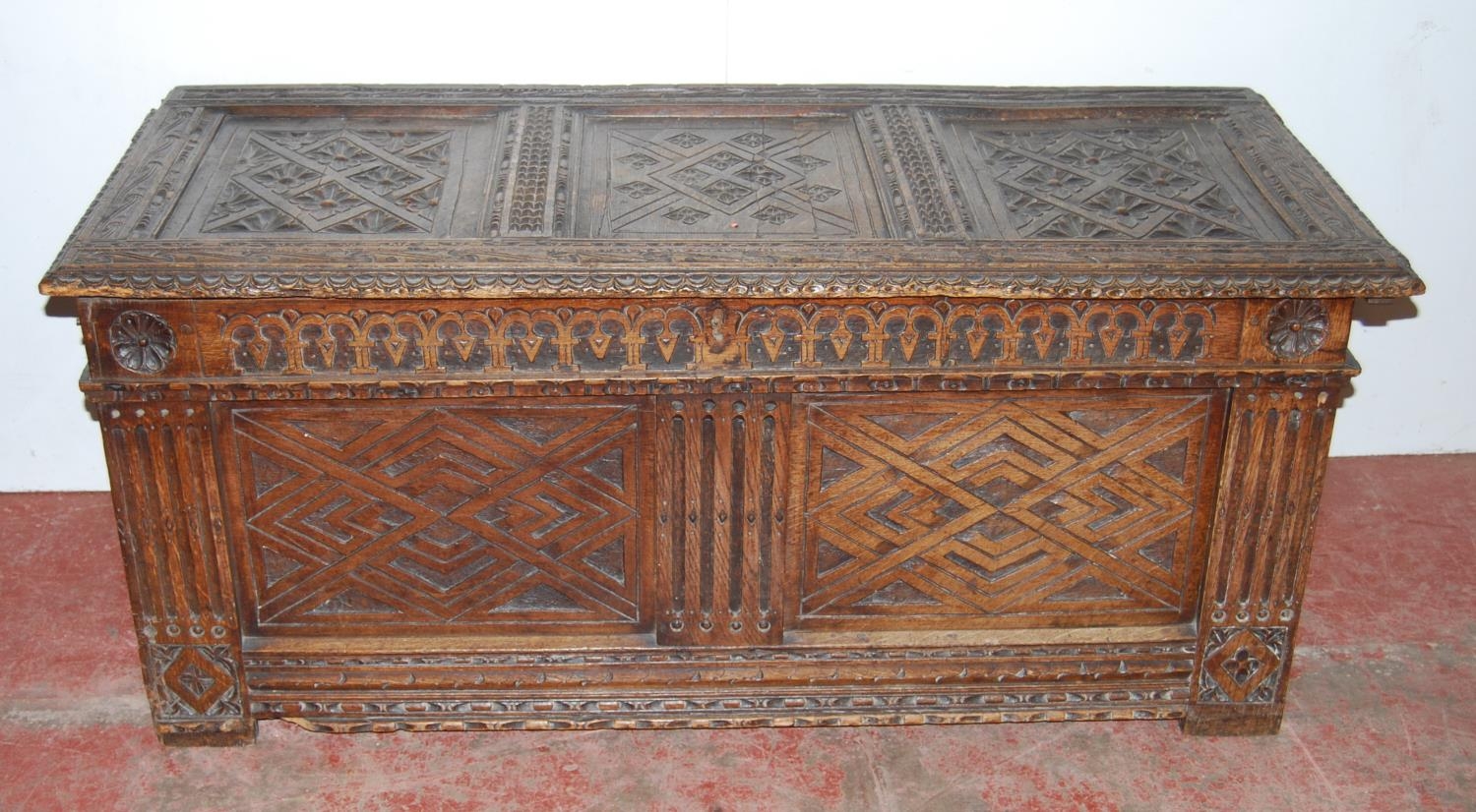 19th century carved oak coffer, the hinged top with three panels, with floral roundels, above