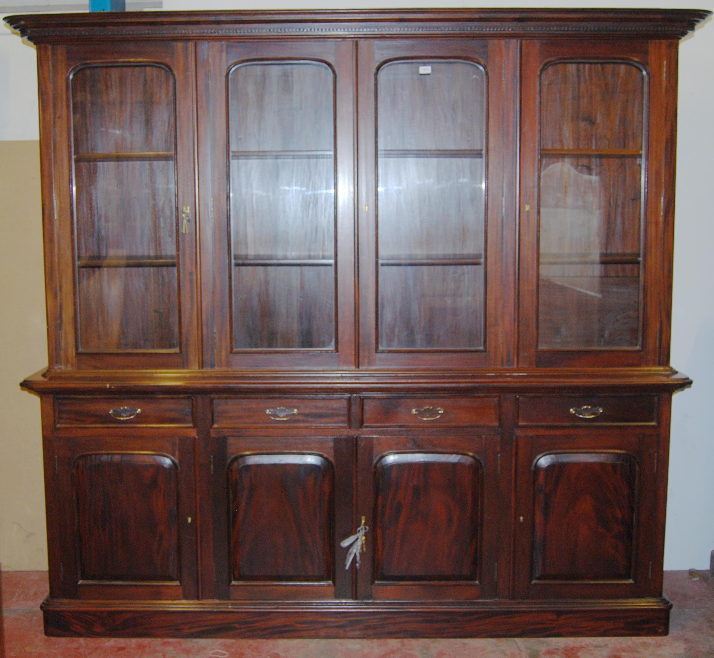 Victorian-style mahogany four-door library bookcase, the dentil decorated cornice above four