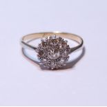 Diamond cluster ring set with a brilliant-cut stone measuring just under .5ct, surrounded by smaller