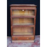 Oak sectional bookcase by Gunn Furniture Company, with three glazed sections above a long drawer,