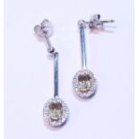 Pair of morganite and diamond drop earrings, each with an oval cluster dependant from a bar.