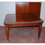 Antique mahogany dining table with two additional leaves, on turned and reeded legs with brass