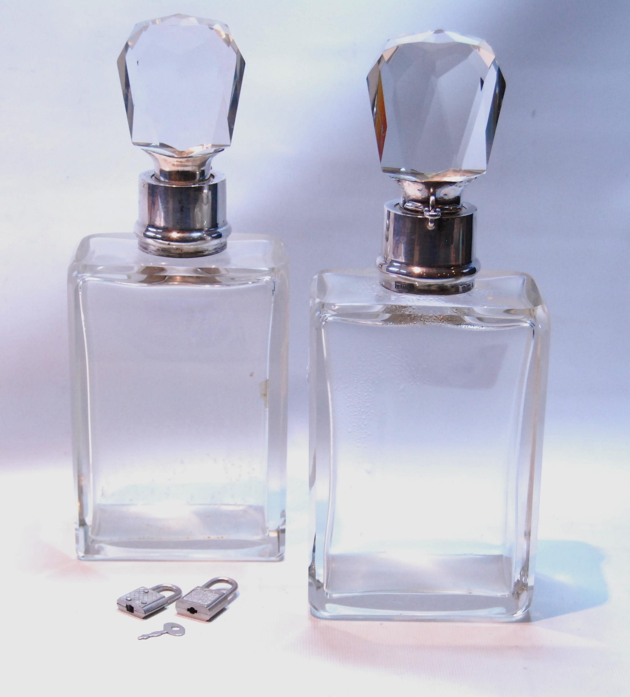 Pair of Edwardian heavy cut glass lockable spirit decanters, plain rectangular, with faceted
