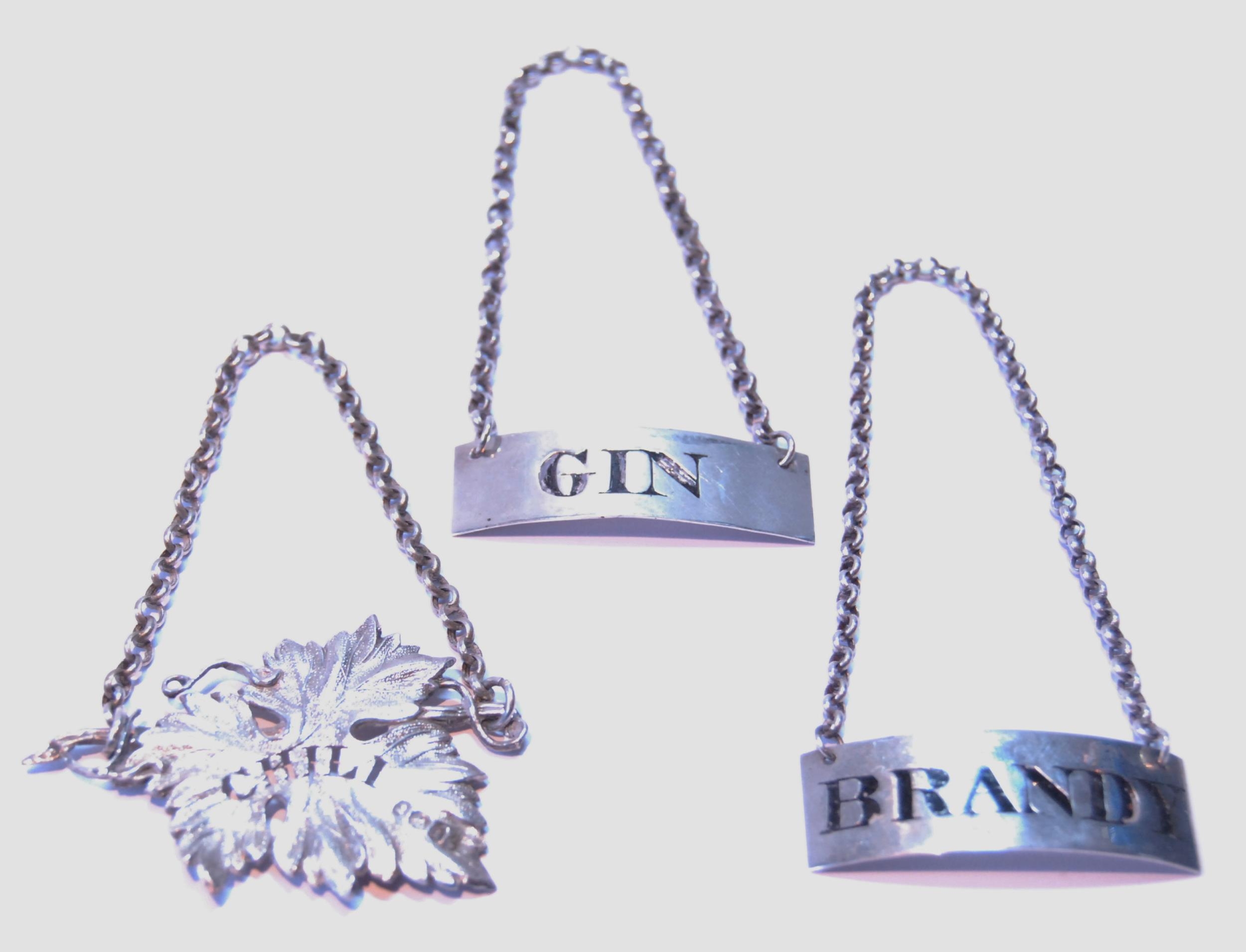 Pair of silver labels engraved for 'Brandy' and 'Gin', by J McKay, Edinburgh 1814/15, and a vine