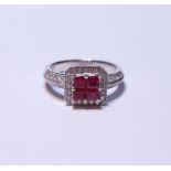 18ct white gold ruby and diamond ring set with four rubies, measuring in total .90ct, flanked by