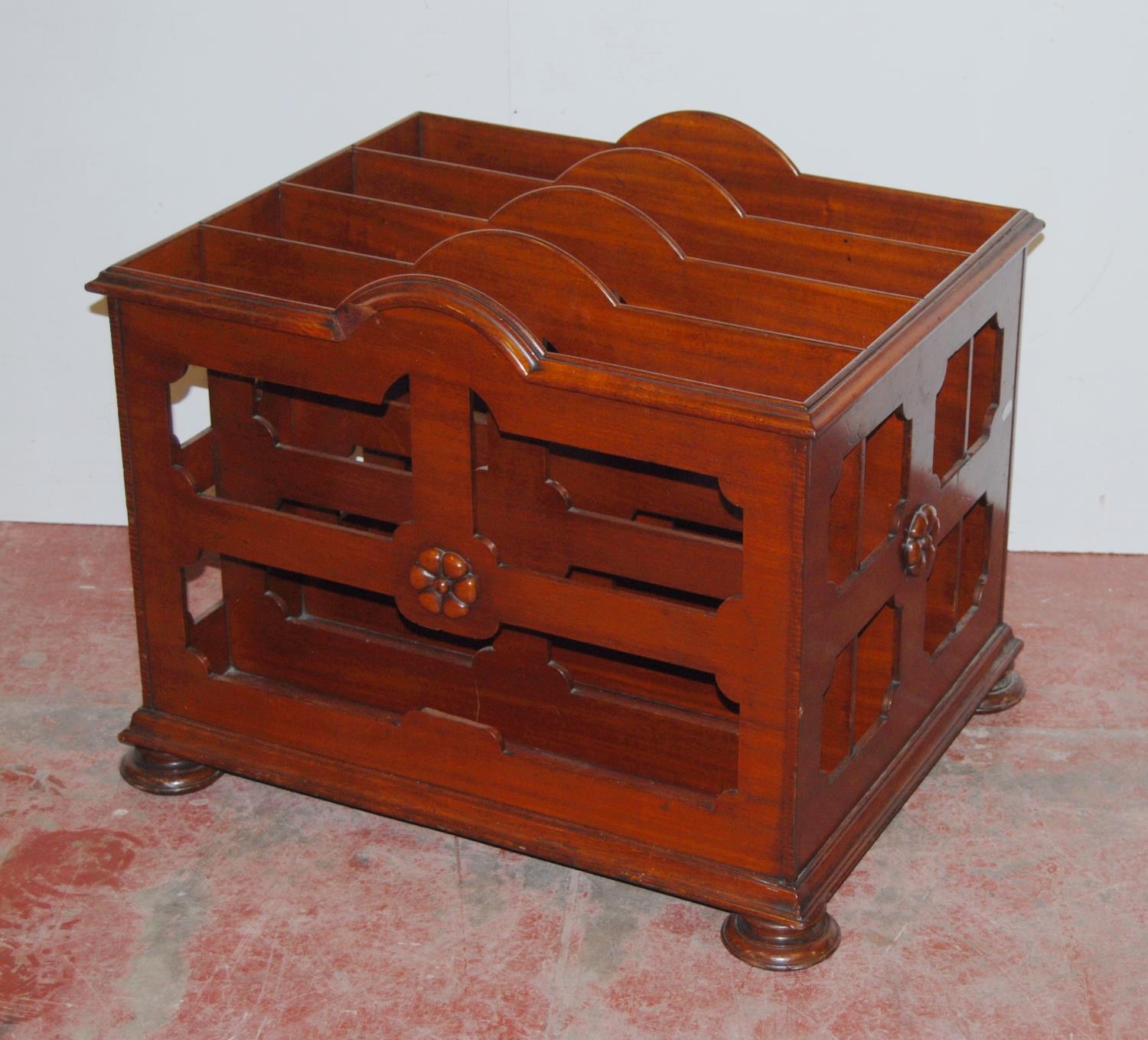 Victorian mahogany canterbury with four shaped divisions, decorated with floral roundels, on bun