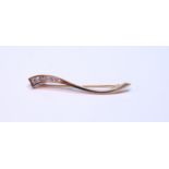 Diamond brooch with five graduated brilliants, tension-set, on wavy tapering bar, in 18ct yellow