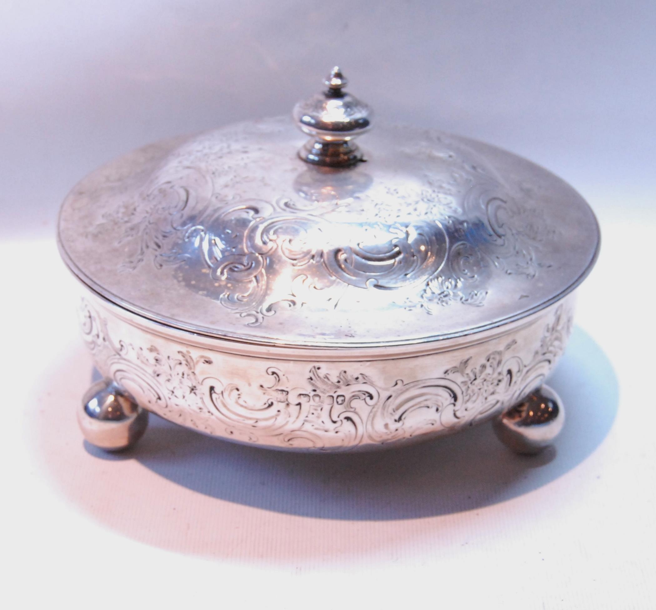 Silver circular bowl with embossed scrolls on ball feet, and the cover, by Charles & George Fox,