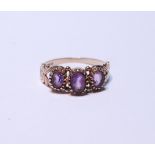 9ct gold amethyst three-stone ring set with three graduated amethysts, stamped '375', size P, 2g