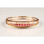 9 carat rose gold ruby stiff bangle set with thirteen graduated rubies 6.5cm diameter , weight 9g